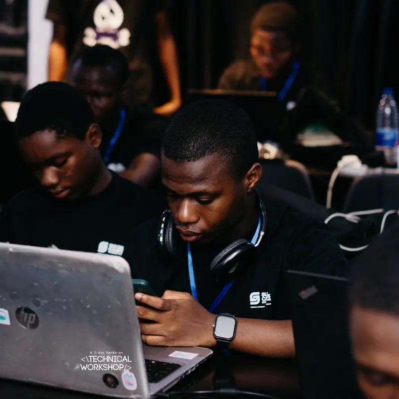 Ezechukwu heads-down on his laptop among other developers at a hands-on workshop