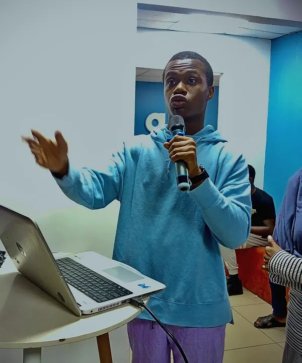 Ezechukwu speaking into a microphone while presenting at a tech event